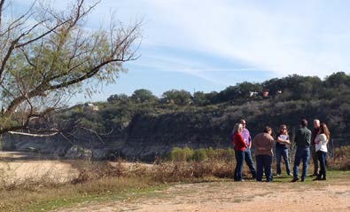 Group of people by reservoir impacted by drought.